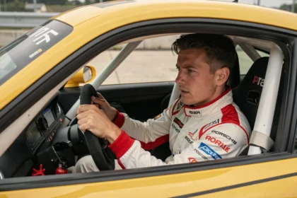 Pilote en combinaison nomex concentré dans le cockpit d'une Porsche GT3 Cup en pit lane lors d'une journée piste